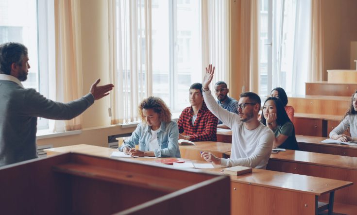 A participant raises his hand to ask a question during a training session